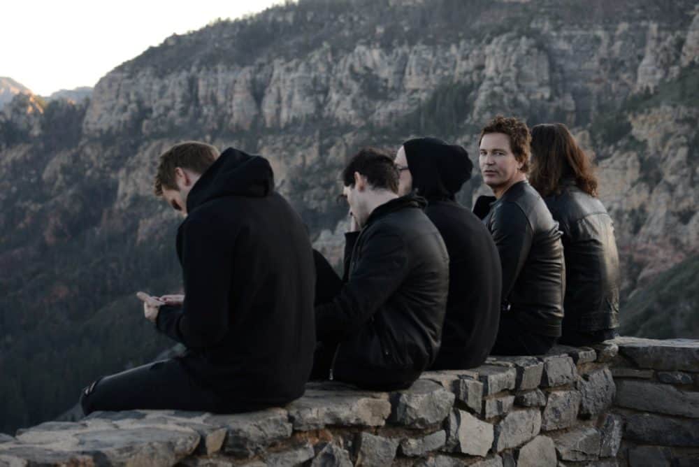 5 People sitting above a mountain