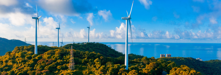 wind turbines with ocean in the background