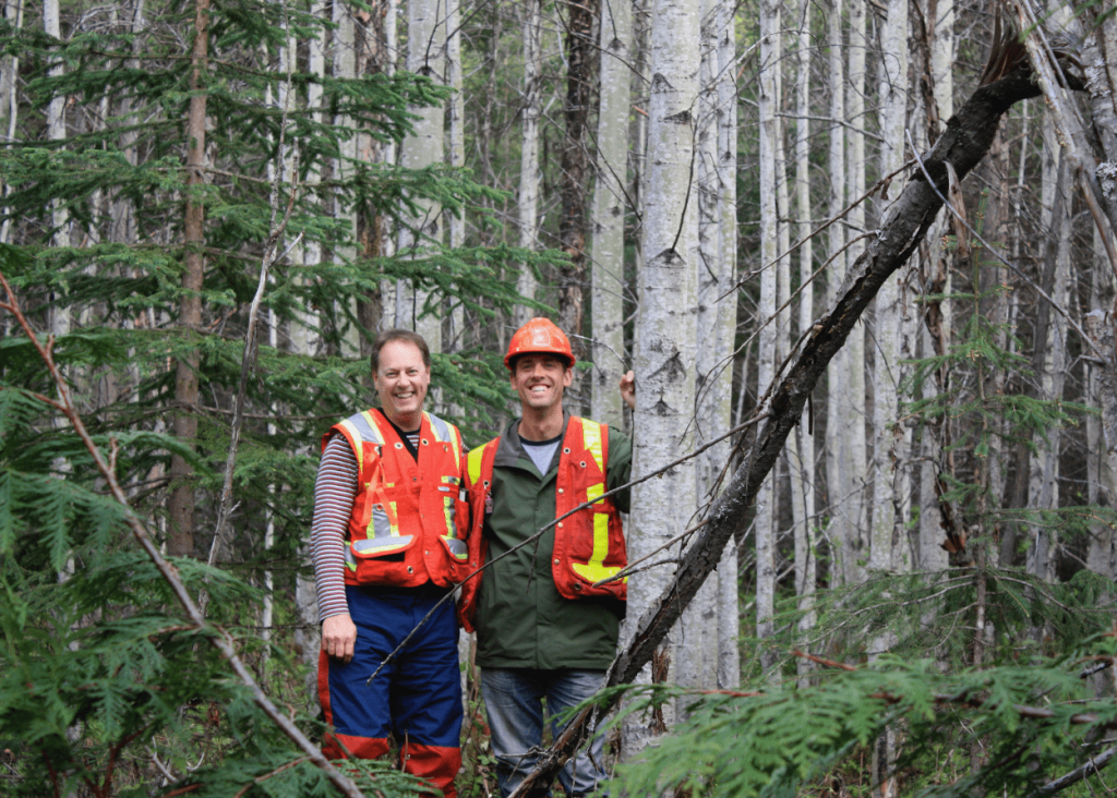 Two people in vests in a forest