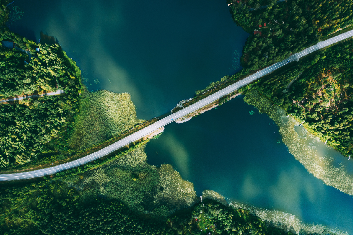 Aerial view of bridge asphalt road with cars and blue water lake