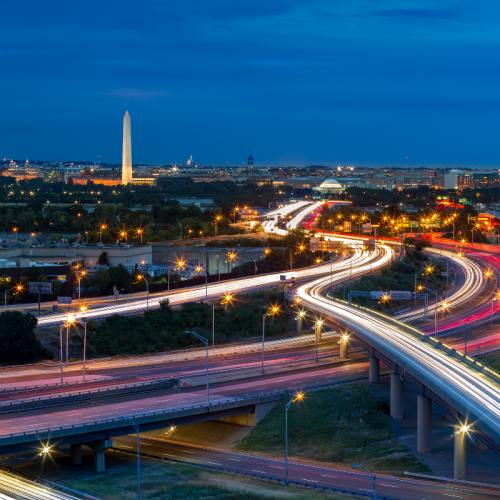 Washington, D.C. cityscape at dusk with light trails from highway traffic